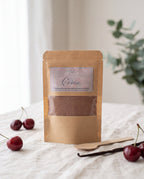 Poudre parfumée Cerise L&E pour aspirateur, sachet kraft et cuillère en bois