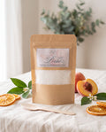 Poudre parfumée Pêche L&E pour aspirateur, sachet kraft et cuillère en bois
