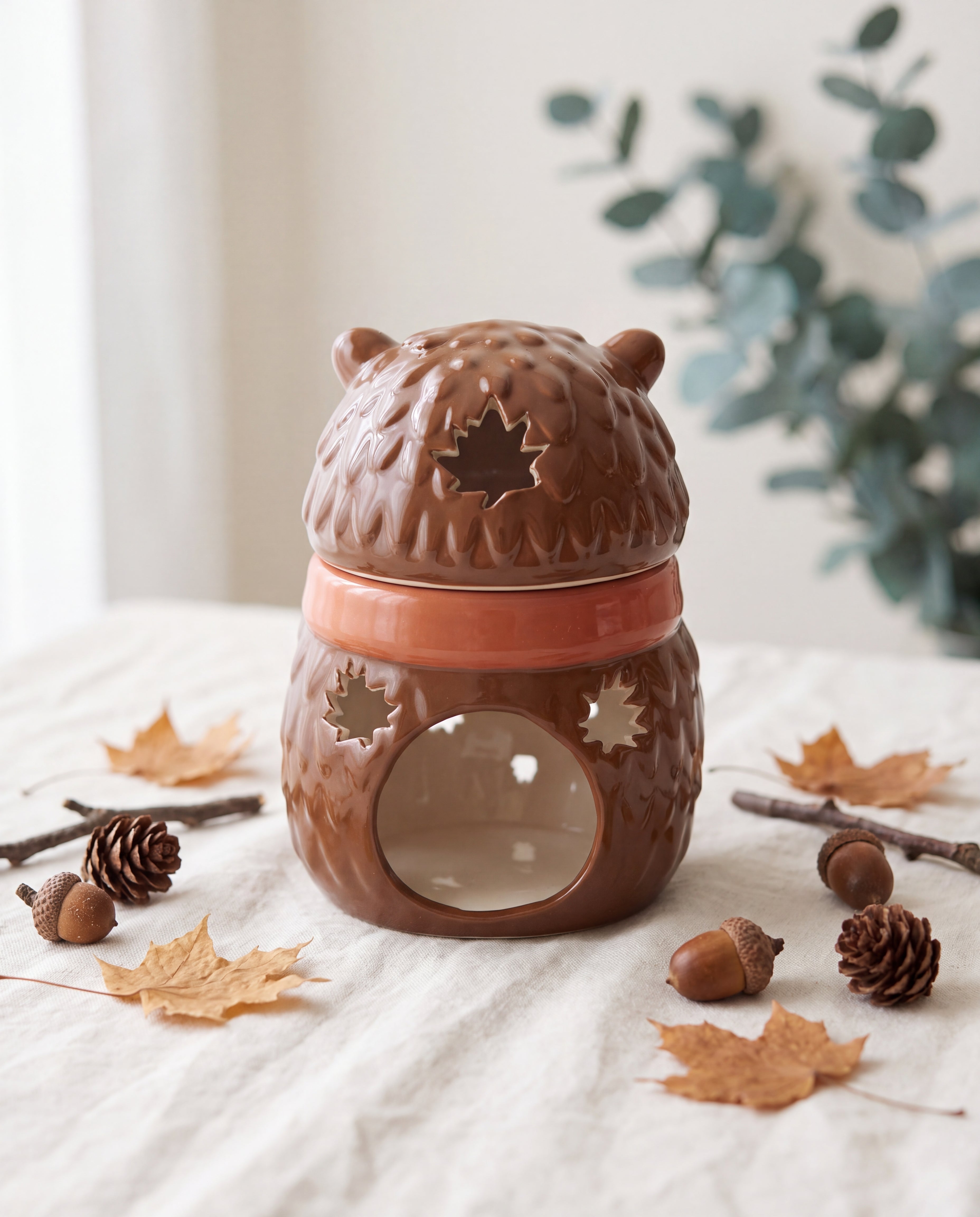 Brûle-parfum Hérisson L&E posé dans un décor de sous-bois